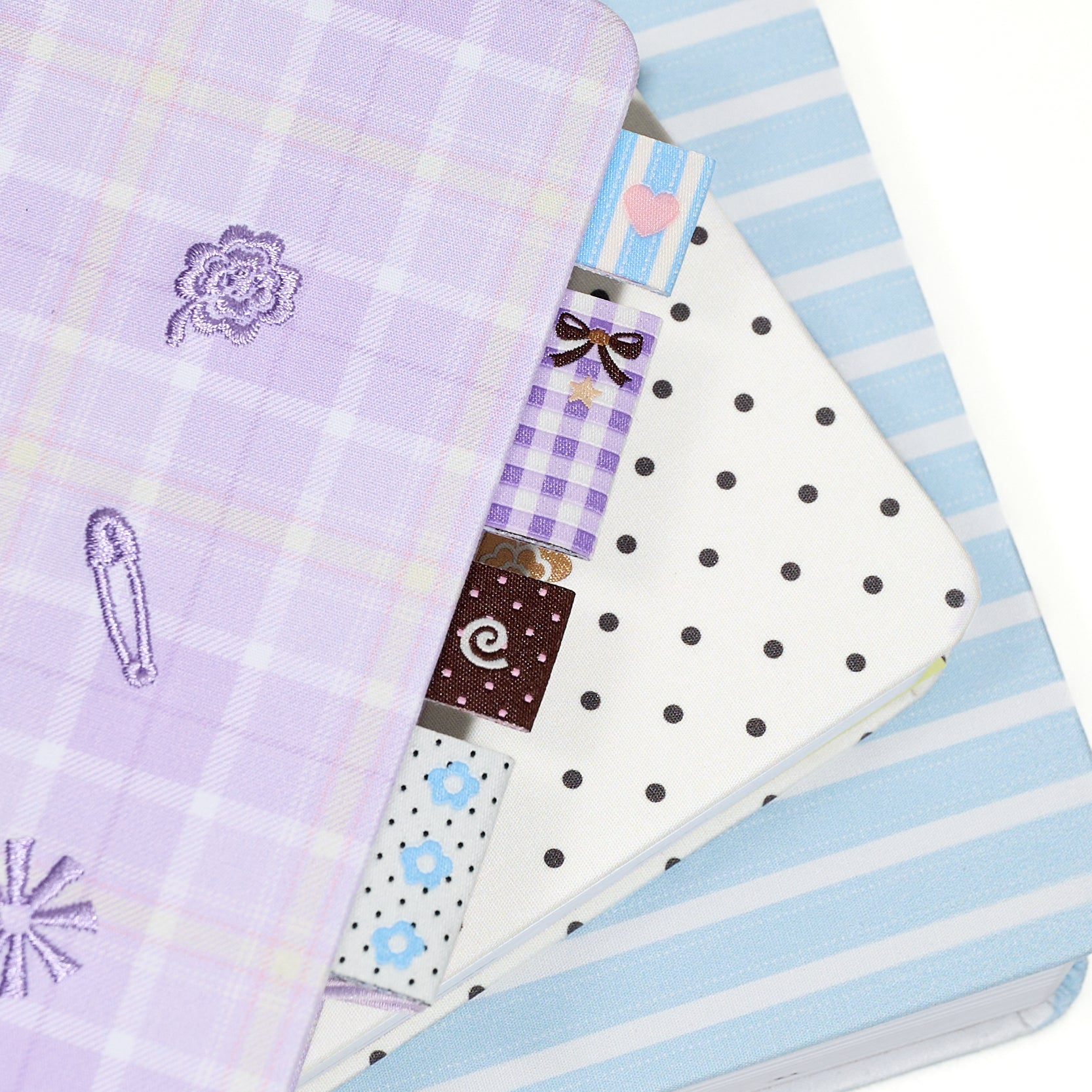 Set of three fabric sew in label bookmark tabs with 4 different patterns on a white background
